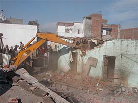 A Municipal Corporation bulldozer demolishes a building in Sunet village during the anti-encroachment drive in Ludhiana