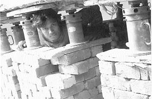 A worker peers through a row of jacks which are used to raise houses