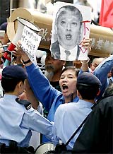 A protester holds up a portrait of Hong Kong Chief Executive Tung Chee-Hwa in front of a mock coffin outside the Legislative Council in Hong Kong on Wednesday