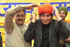 Union Minister of State for External Affairs Vinod Khanna adjusts a turban presented to him by the BJP workers at a function in Jammu 