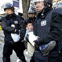 Riot policemen arrest a farmer during a farmers� rally near the National Assembly in Seoul 