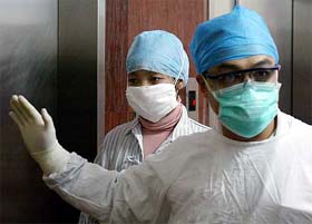 A Chinese waitress (L), who was declared a suspected SARS case, is submitted into the SARS ward of the No. 8 People's Hospital in Guangzhou