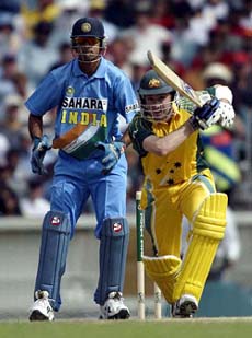 Australian batsman Michael Clarke (right) straight drives a shot for four runs