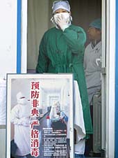 A masked medical worker looks out from a fever clinic at a railway station in Beijing
