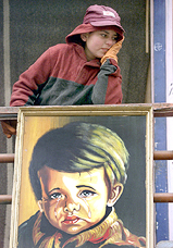 A boy looks out from the balcony of his home on a chilly Saturday morning in Srinagar