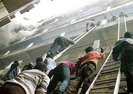 People come down via ladders when a high-rise in Patna caught fire due to short-circuit on Saturday