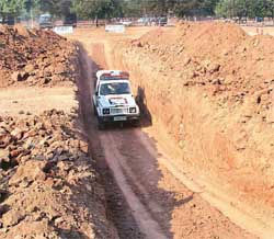 A Chandigarh Police Gypsy passes through a trench during a driving test 