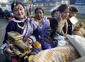 Women wearing traditional dresses sit inside a vintage car at the Vintage Car Rally in Kolkata on Sunday