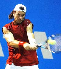 Carlos Moya of Spain forces a backhand return against Paradorn Srichapan of Thailand during the final of the TATA Open in Chennai