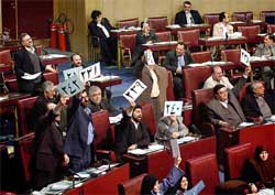 Iranian MPs hold up their numbers in protest during a Parliament session in Tehran on Sunday