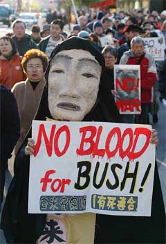 A protester holds an anti-war placard during a protest march against the government's decision to send troops to Iraq, in Tokyo's Ginza shopping district on Sunday