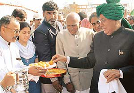 Haryana Chief Minister Om Prakash Chautala having a ''laddoo'' after laying the foundation stone of the Government College for Women in Sector 14, Panchkula, on Tuesday. 