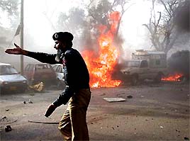 A policeman stops onlookers at the site of an explosion in front of a church in Karachi 