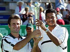 Fabrice Santoro of France and Mahesh Bhupathi of India hold the trophy after winning the doubles final at the Heineken Open 