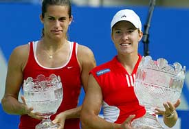 Justine Henin-Hardenne of Belgium and Amelie Mauresmo of France pose with their trophies after the women's final of the Sydney International tournament 