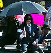 Michael Jackson's fans reach out to touch him as he sits on top of his limo in Santa Maria, California