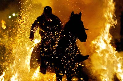 A man rides his horse through flames during the annual religious celebration on the night before Saint Anthony's Day