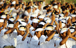 Balinese Hindus from Legian village pray on the beach at sunset during the Karya Mamungkah Agung ceremony
