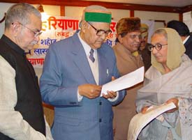 Haryana Governor Babu Parmanand presents a cheque for Rs 5 lakh to Ms Kulwant Kaur 