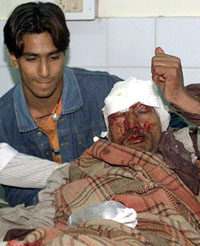 An injured policeman is helped by a relative inside a hospital after he was wounded in a mine blast