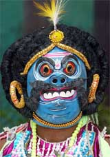 A masked folk dancer attends a rehearsal for the Republic Day parade