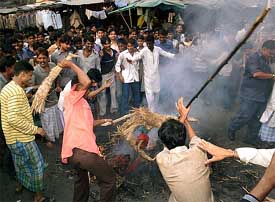 Angry protesters beat an effigy of Taslima Nasreen in Kolkata