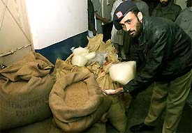 A Pakistani official shows bomb-making material seized from a house after a police raid in Karachi 