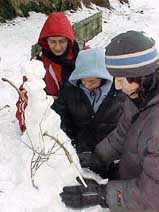 Tourists make a snowman following fresh snowfall in Kufri�