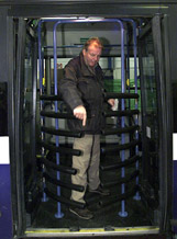 A journalist points out the back door of a bus fitted with a protective metal gate which was displayed to reporters at the Israeli Military Industries headquarters 