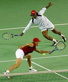 Martina Navratilova of the USA and Leander Paes attempt to play a shot during their mixed doubles match against South Africa's Chris Haggard and France's Emilie Loit 