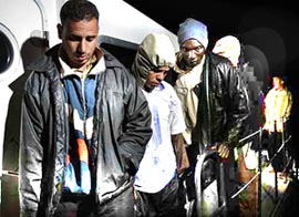 Immigrants sit on a Spanish civil guard vessel after they were intercepted trying to reach the coast of Fuerteventura