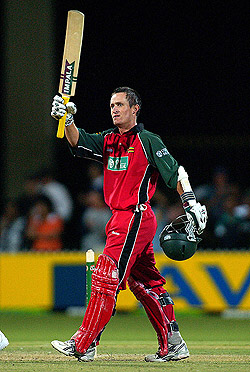 Stuart Carlisle of Zimbabwe raises his bat after completing his century