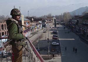 A BSF soldier guards a desert street in Srinagar 