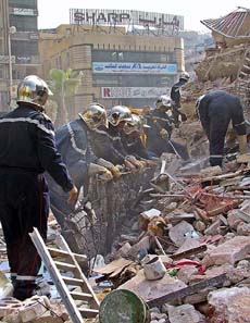Rescue workers look for survivors under the rubble of a collapsed building in Cairo