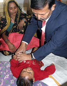 A Bangladeshi doctor treats a baby with high fever at a hospital at Goalando