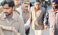 Pakistani spy Abid Mehmood (left) and Deputy Superintendent of Burail Jail V.M. Gill being taken to the Operation Cell of the police after being produced in a court