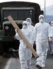 South Korean soldiers prepare disinfectant for health officials at a farm affected by bird flu in Chonan, some 90 km south of Seoul