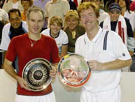 John McEnroe of the US and Mark Woodforde of Australia hold their trophies after winning the Legends' doubles final against Australia's Pat Cash and Kim Warwick 