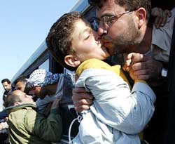 An unidentified released Palestinian prisoner kisses his son out of a bus window on arrival in Gaza Strip 