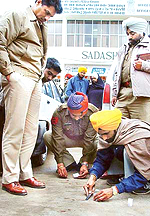 Police personnel collect samples of blood from the spot where two youths attempted an armed robbery at Dera Bassi on Friday.