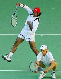 Martina Navratilova of the US crouches as her partner Leander Paes hits a smash during their mixed doubles semifinal against Jonathan Erlich of Israel and Liezel Huber of South Africa 
