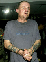 Alan John Kiernan, a 35-year-old Briton, is led by the police after his arrest 