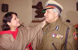 The wife of Mr K.K. Paul adjusts his cap before he leaves for the Police Headquarters to formally take over as the Delhi Police Commissioner on Saturday.