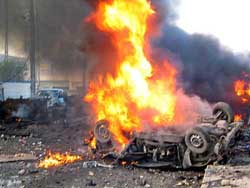 A car burns following an explosion in front of a local police station in Mosul, Iraq, on Saturday.