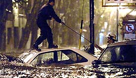 Rescue personnel work on trapped cars on a flooded street of Buenos Aires 