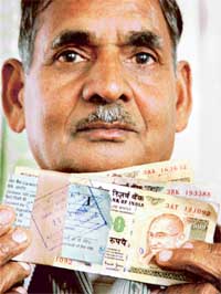 M.R. Singla shows the currency wad carrying two fake notes
