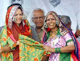 Congress President Sonia Gandhi tries out a Banjara dress at the golden jubilee celebrations of the Banjara Seva Sangh at Digras in Maharashtra
