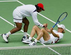 Martina Navratilova, left, of the US is helped to her feet by her partner, India's Leander Paes, during their mixed doubles final at the Australian Open