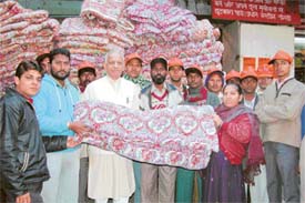 Mr Jagdish Tangri presents a quilt to a needy woman in Gur Mandi in Ludhiana