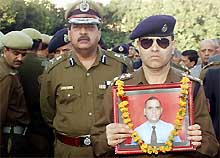 A police officer carries the portrait of Deputy Inspector General Mohammed Amin Bhat during a memorial service